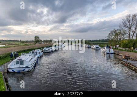 Barche ormeggiate e crociere in cabina sul fiume ANT a Ludham bridge, Norfolk Broads Foto Stock