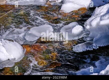 Concetto di bellezza e grandezza della natura: Acque cristalline in un fiume di montagna con un bordo di ghiaccio spettacolare Foto Stock