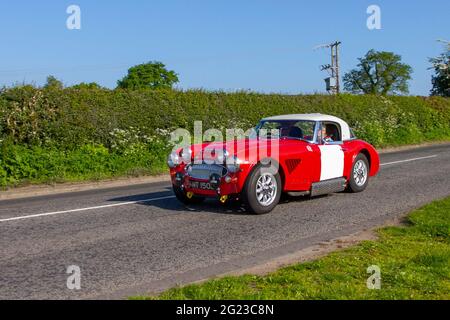 1966, 60s rosso Austin Healey 2912cc benzina, in rotta per Capesthorne Hall mostra di auto classica, Cheshire, Regno Unito Foto Stock