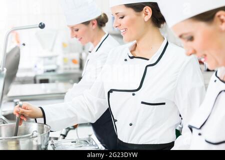 Gli chef di sesso femminile al lavoro in cucina industriale di mensa Foto Stock