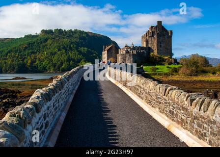 Una vista del sentiero che conduce fuori sul ponte e attraverso il lago di mare fino al Castello di Eilean Donan nelle Highlands della Scozia. Foto Stock