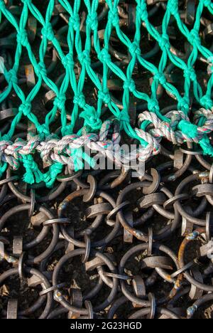 Una sintesi astratta di alcune catene da pesca in metallo e reti sul porto. Foto Stock