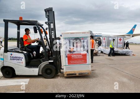 Phnom Penh, Cambogia. 8 Giugno 2021. Un lavoratore trasporta un pacchetto di vaccini cinesi COVID-19 all'aeroporto internazionale Phnom Penh di Phnom Penh, Cambogia, 8 giugno 2021. La campagna di vaccinazione COVID-19 della Cambogia ha ricevuto un altro impulso dopo che il paese ha ottenuto un nuovo lotto di vaccini cinesi il martedì. Yok Sambath, segretario di stato del ministero della salute cambogiano, ha dichiarato che il nuovo arrivo includeva il vaccino Sinopharm donato dal governo cinese e quelli acquistati dalla società biofarmaceutica cinese Sinovac Biotech. Credit: Phearum/Xinhua/Alamy Live News Foto Stock