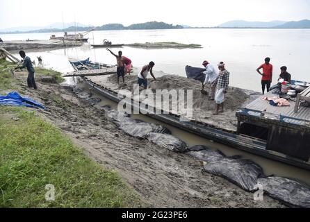 Guwahati, Guwahati, India. 8 Giugno 2021. I lavoratori hanno portato la sabbia in una barca per riempire i sacchi che saranno messi sulla riva del fiume Brahmaputra per controllare l'erosione del suolo prima della stagione monsone a Guwahati Assam India su Martedì 8 giugno 2021 Credit: Dasarath Deka/ZUMA Wire/Alamy Live News Foto Stock