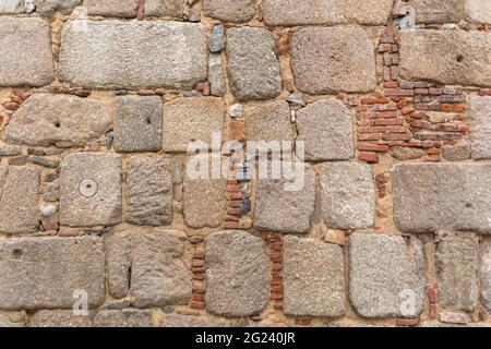 Architettura texture, dettagliate e rustiche di irregolare accoppiato muratura granito mix con ceramica argilla mattoni, tradizionale... Foto Stock