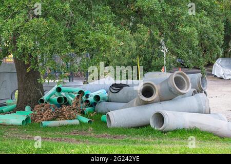 Pile di grandi tubi di drenaggio sul lato della strada nel quartiere Uptown di New Orleans Foto Stock