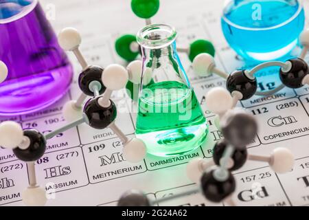 Modelli molecolari e vetreria da laboratorio con liquidi su tavola periodica Foto Stock