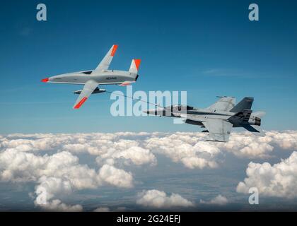 Un aereo di prova Stingray T1 Boeing senza equipaggio della U.S. Air Force mq-25, a sinistra, rifornisce un aereo da combattimento Super Hornet F/A-18 con equipaggio durante i test di volo sull'aeroporto MidAmerica 4 giugno 2021 a Mascoutah, Illinois. Il volo di successo ha dimostrato che la MQ-25 Stingray è in grado di svolgere la propria missione in autocisterna utilizzando il metodo standard della marina di rifornimento aereo sonda e drogue. Foto Stock