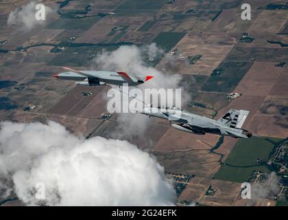 Un aereo di prova Stingray T1 Boeing senza equipaggio della U.S. Air Force mq-25, a sinistra, rifornisce un aereo da combattimento Super Hornet F/A-18 con equipaggio durante i test di volo sull'aeroporto MidAmerica 4 giugno 2021 a Mascoutah, Illinois. Il volo di successo ha dimostrato che la MQ-25 Stingray è in grado di svolgere la propria missione in autocisterna utilizzando il metodo standard della marina di rifornimento aereo sonda e drogue. Foto Stock