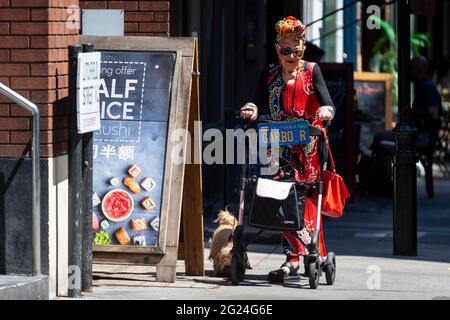 Londra, Regno Unito. 8 giugno 2021. UK Weather - una donna elegantemente vestita cammina il suo cane vicino a Cambridge Circus in un pomeriggio caldo e soleggiato, quando le temperature sono salite a 25C nella capitale. Credit: Stephen Chung / Alamy Live News Foto Stock