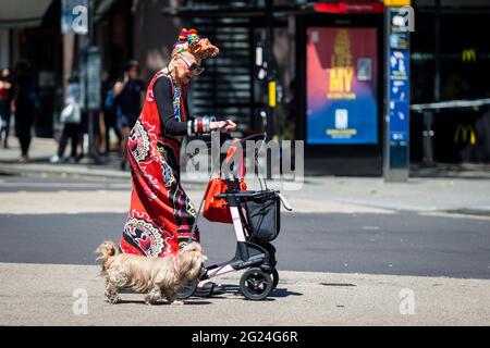 Londra, Regno Unito. 8 giugno 2021. UK Weather - una donna elegantemente vestita cammina il suo cane vicino a Cambridge Circus in un pomeriggio caldo e soleggiato, quando le temperature sono salite a 25C nella capitale. Credit: Stephen Chung / Alamy Live News Foto Stock