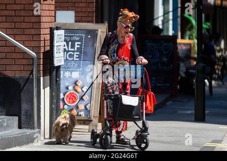 Londra, Regno Unito. 8 giugno 2021. UK Weather - una donna elegantemente vestita cammina il suo cane vicino a Cambridge Circus in un pomeriggio caldo e soleggiato, quando le temperature sono salite a 25C nella capitale. Credit: Stephen Chung / Alamy Live News Foto Stock