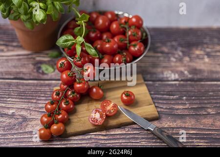 frische, rote und reife Tomaten werden zubereitet, auf einen Holzbrett kleingeschnitten. Pomodori freschi, rossi e maturi sono preparati, tagliati in pi piccolo Foto Stock