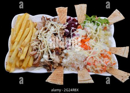 Piatto Shawarma con patatine fritte. Verdure bollite e riso su sfondo nero. Concetto di Street food Foto Stock