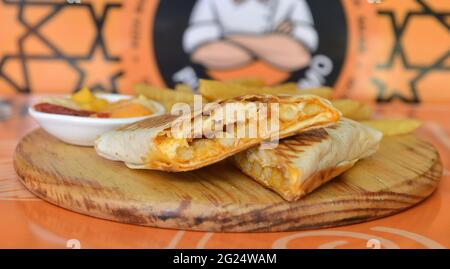 Tacos francesi con pollo. Servito con patatine fritte, maionese, ketchup e senape. Su legno Foto Stock