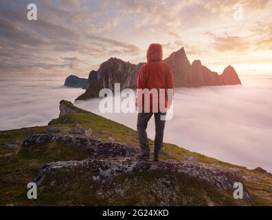 Un turista che gode di una vista sul monte Hesten, Senja, Norvegia. Trekking in Norvegia, concetto di vita attiva Foto Stock