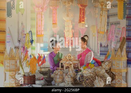 Ritratto di due donne in abiti tradizionali thailandesi seduti tra lanterne, Thailandia Foto Stock