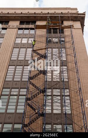 Lavoratori su un ponteggio all'esterno del Morgan Processing and Distribution Center (Morgan North) a Chelsea a New York venerdì 5 giugno 2021. I piani superiori dell'enorme struttura, che occupa un intero blocco cittadino, sono in fase di sviluppo da parte di Tishman Speyer in uffici. (© Richard B. Levine) Foto Stock