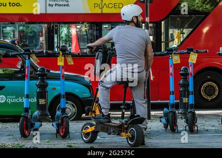 Londra, Regno Unito. 8 Giugno 2021. Un pilota di uno scooter illegale non è persuaso ad andare legale - scooter elettrici (e-scooter) sono ora disponibili per il noleggio in un piccolo numero di quartieri di Londra. Questo è l'unico modo per guidare legalmente un e-scooter su strade pubbliche o in altri luoghi pubblici di Londra. Il noleggio e-scooter è fornito da tre operatori diversi: Dott., Lime e TIER. Credit: Guy Bell/Alamy Live News Foto Stock