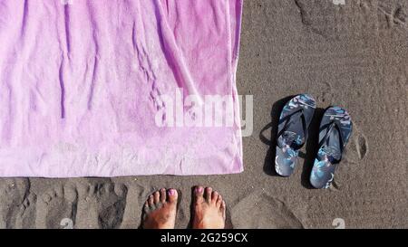 Vista aerea di una donna a piedi nudi sulla spiaggia da un telo da spiaggia, Malaga, Spagna Foto Stock