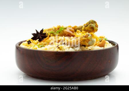 Pollo biryani , pollo in stile kerala dhum biriyani fatto con riso jeera e spezie disposti in una tavola di legno con sfondo bianco, isolato Foto Stock