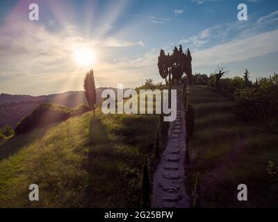 Scale in pietra naturale con splendidi paesaggi e cipressi al tramonto in Lombardia, Italia Foto Stock