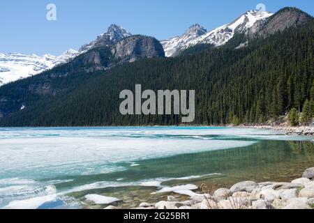 Bellissimo paesaggio in una giornata di sole al lago ghiacciato Luise. Persone in lontananza a piedi vicino alla foresta e il lago. Banff National Park, Alberta, CA Foto Stock