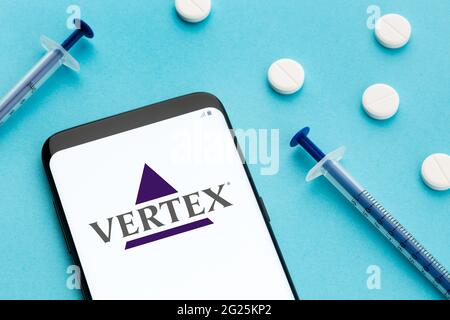 Galizia, Spagna; 8 Giugno 2020 : smartphone con logo Vertex sullo schermo e pillole e siringa su sfondo blu Foto Stock