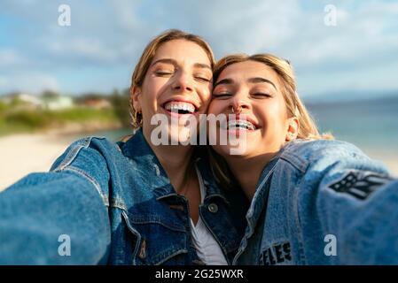 Due belle amiche sorridenti che prendono un selfie Foto Stock