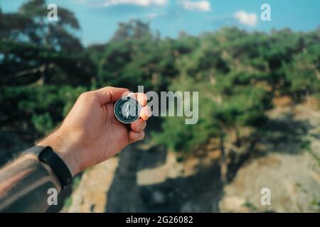 L'uomo tiene una bussola nella foresta. Foto Stock