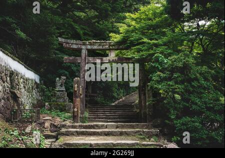 Vecchia porta torri in pietra su un sentiero scale nel parco forestale sul Monte Misen a Miyajima, Hiroshima, Giappone Foto Stock