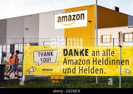 Dortmund, Germania, 8 giugno 2021: Su un grande banner all'ingresso del personale del parco logistico Amazon di Dortmund, i dipendenti sono ringraziati per il loro lavoro come eroi durante la pandemia della corona. --- Dortmund, 08.06.2021: Auf einem Großen Banner am Personaleingang des Amazon Logistikparks in Dortmund Wird den Mitarbeiterinnen und Mitarbeitern für deren Arbeit während der Corona-Pandemie als Heldinnen und Helden gedankt. Foto Stock