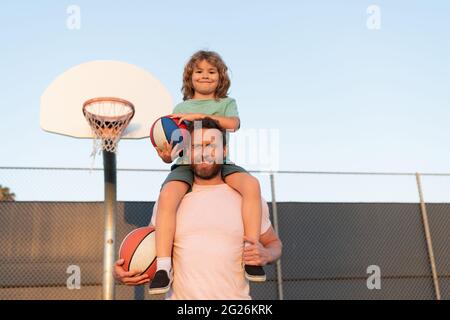 felice padre e figlio giocare a basket con palla sul campo da gioco, togetherness Foto Stock