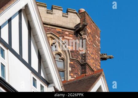 Un gargoyle protudes dalla torre castellata di Homerton College, Cambridge, UK. Foto Stock