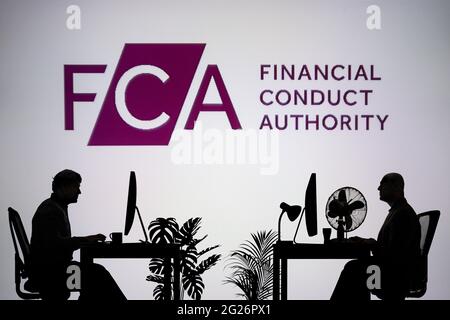 Il logo FCA viene visualizzato su uno schermo LED sullo sfondo, mentre due persone con silhouette lavorano in un ambiente d'ufficio (solo per uso editoriale) Foto Stock