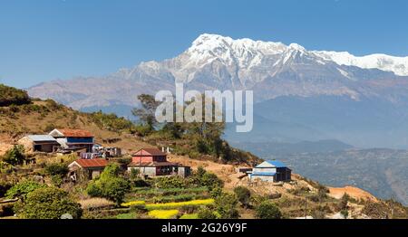 Monte Annapurna e villette nepalesi. Sentiero di trekking Annapurna, Nepal Foto Stock