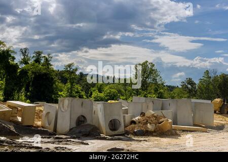 Costruzione di tubi in calcestruzzo di impianti di drenaggio lavoro sulla strada per fognature di acqua drenata Foto Stock