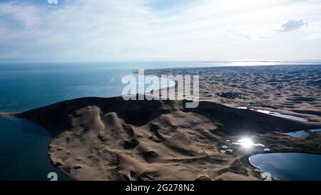 (210609) -- XINING, 9 giugno 2021 (Xinhua) -- Foto aerea scattata il 28 luglio 2020 mostra lo scenario del lago Qinghai nella provincia Qinghai della Cina nord-occidentale. Situato nella parte nord-orientale dell'altopiano Qinghai-Tibet, il lago Qinghai è fondamentale per mantenere l'equilibrio ecologico nella Cina occidentale. Si tratta inoltre di una barriera naturale per il controllo della diffusione verso est della desertificazione e per garantire la sicurezza delle aree agricole nella Cina orientale. Negli ultimi anni, il governo cinese ha attuato diversi progetti ecologici nel bacino del lago Qinghai, e ha ottenuto notevoli risultati a restori Foto Stock