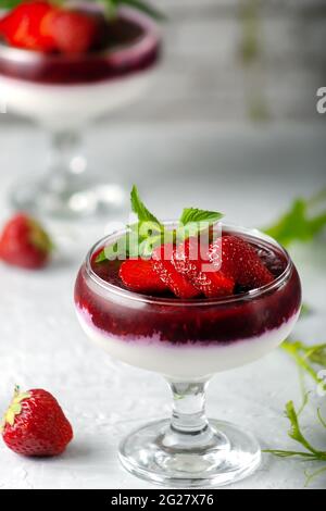 Tradizionale dessert italiano alla vaniglia panna cotta alla fragola in verina con frutti di bosco freschi. Spazio di copia. Foto Stock