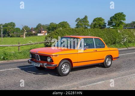 1976 70s arancione BMW 2002 TII, 1990cc benzina 2DR berlina lungo il tragitto per Capesthorne Hall Classic car show, Cheshire, Regno Unito Foto Stock