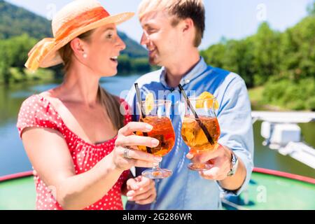 Happy couple in love on river cruise drinking coctails in summer enjoying their time Stock Photo