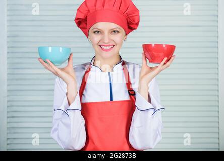 Calcola il tuo cibo servings dimensioni. Concetto di dieta e dieta. Donna cuoco tenere ciotole. Quante porzioni vorreste mangiare. Calcolare la quantità di calorie Foto Stock