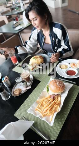 Young Lady mangiare fuori ristorante informale a cinque stelle mangiare un pasto Foto Stock