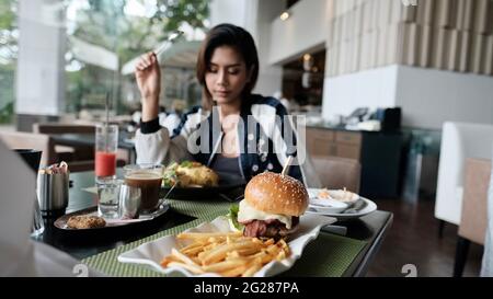 Young Lady mangiare fuori ristorante informale a cinque stelle mangiare un pasto Foto Stock