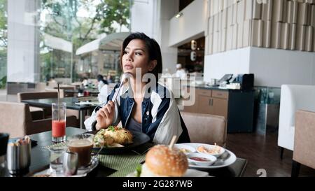 Young Lady mangiare fuori ristorante informale a cinque stelle mangiare un pasto Foto Stock