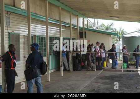 Papua Nuova Guinea, Goroka - edificio dell'aeroporto; passeggeri in attesa di salire a bordo dell'aereo. Passagiere, die darauf warten, das Flugzeug zu besteigen. Lotnisko Foto Stock