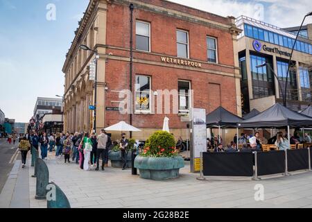 Sheffield UK: 17 aprile 2021: Coda socialmente distanziata a Wetherspoons come pub riaprono dopo la pandemia. The New Normal su West Street Foto Stock