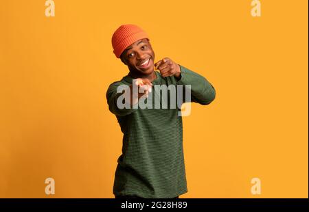 Positivo giovane africano Hipster Guy che punta a macchina fotografica e dice Gotcha Foto Stock
