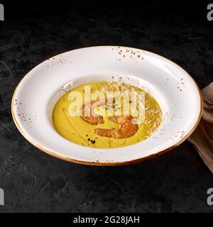 Zuppa di formaggio con gamberi. Zuppa di panna con Brie, Parmigiano, Blu DOOR, mozzarella, cagliata e crema con gamberi di tigre torrefatti alla tempura. Foto per il menu, Foto Stock