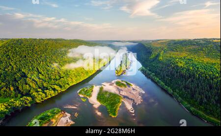 Volo attraverso il maestoso fiume foggy e la lussureggiante foresta verde all'alba. Fotografia di paesaggio. Dnister, Ucraina, Europa Foto Stock